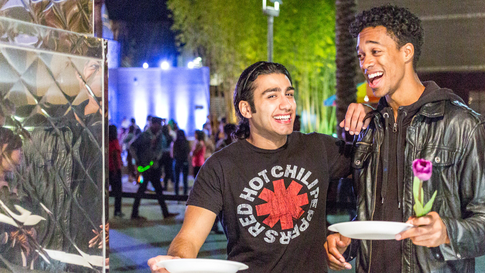 Two students smile as they stand waiting for food at Matador Nights, spring 2013