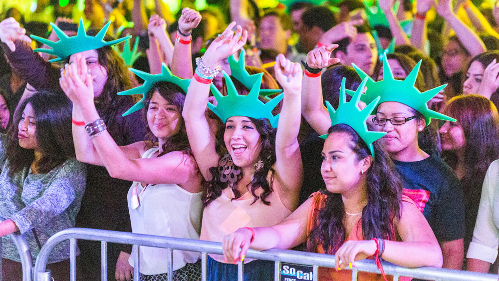 Students in the front of the crowd smile while wearing statue of liberty crowns at Matador Nights, spring 2013