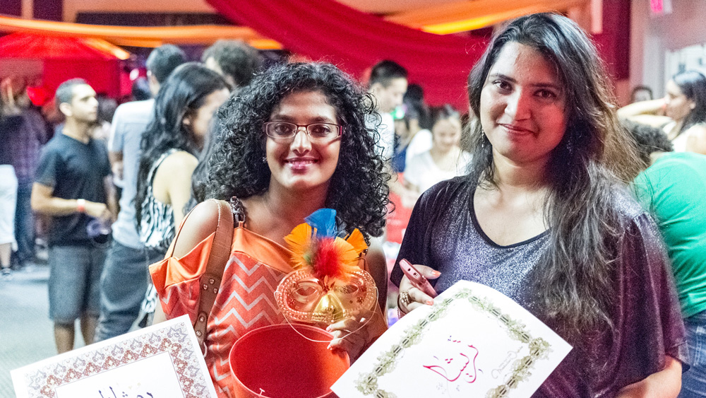 Two students pose with their craft corner and calligraphy creations at the fall 2012 Matador Nights event