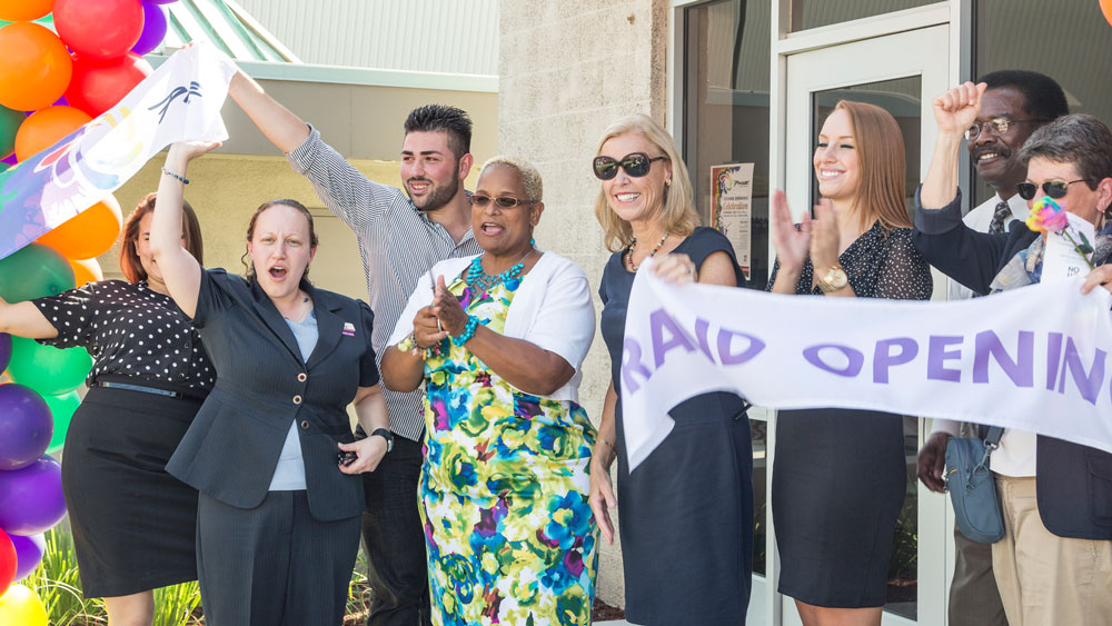 Students, campus staff, campus administrators and USU staff cut the ribbon during the Pride Center Grand Opening