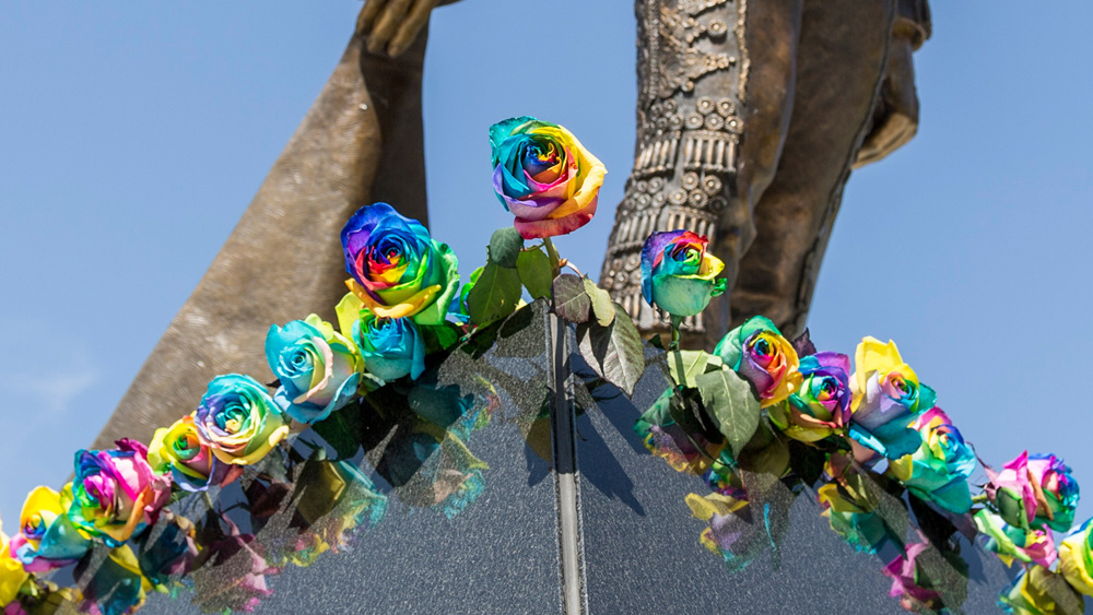 Multi-colored roses adorn the base of the Matador statue during the Pride Center Grand Opening