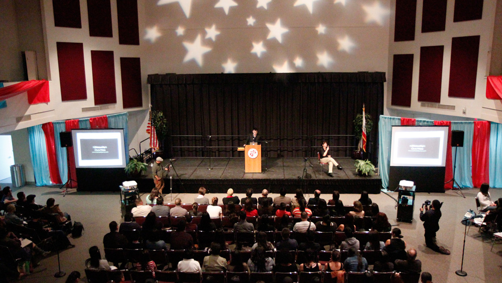 A view of the Northridge Center, USU from the top floor balcony, showing the crowd sitting in front of the stage with Jose Antonio Vargas at the podium during the Define American with Jose Antonio Vargas event