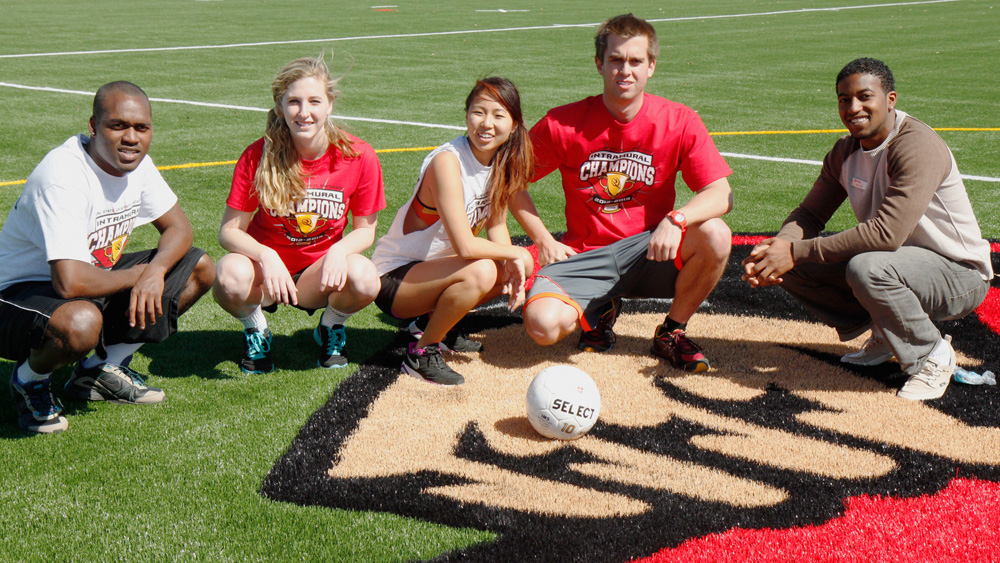 Student intramural participants and staff pose on the new SRC turf field