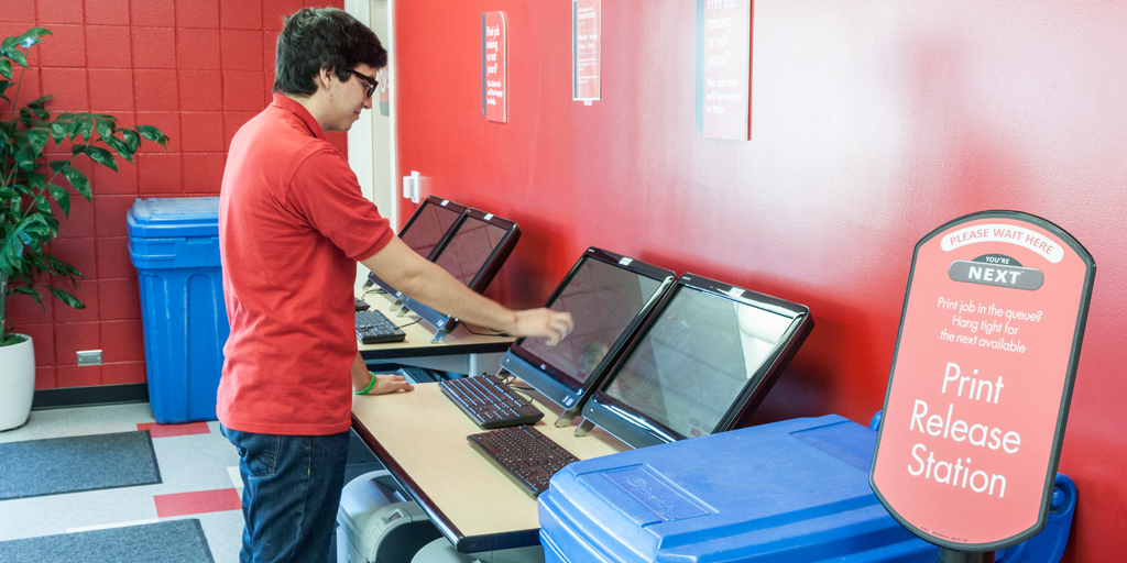 A student interacts with the Print Release station in the USU Computer Lab